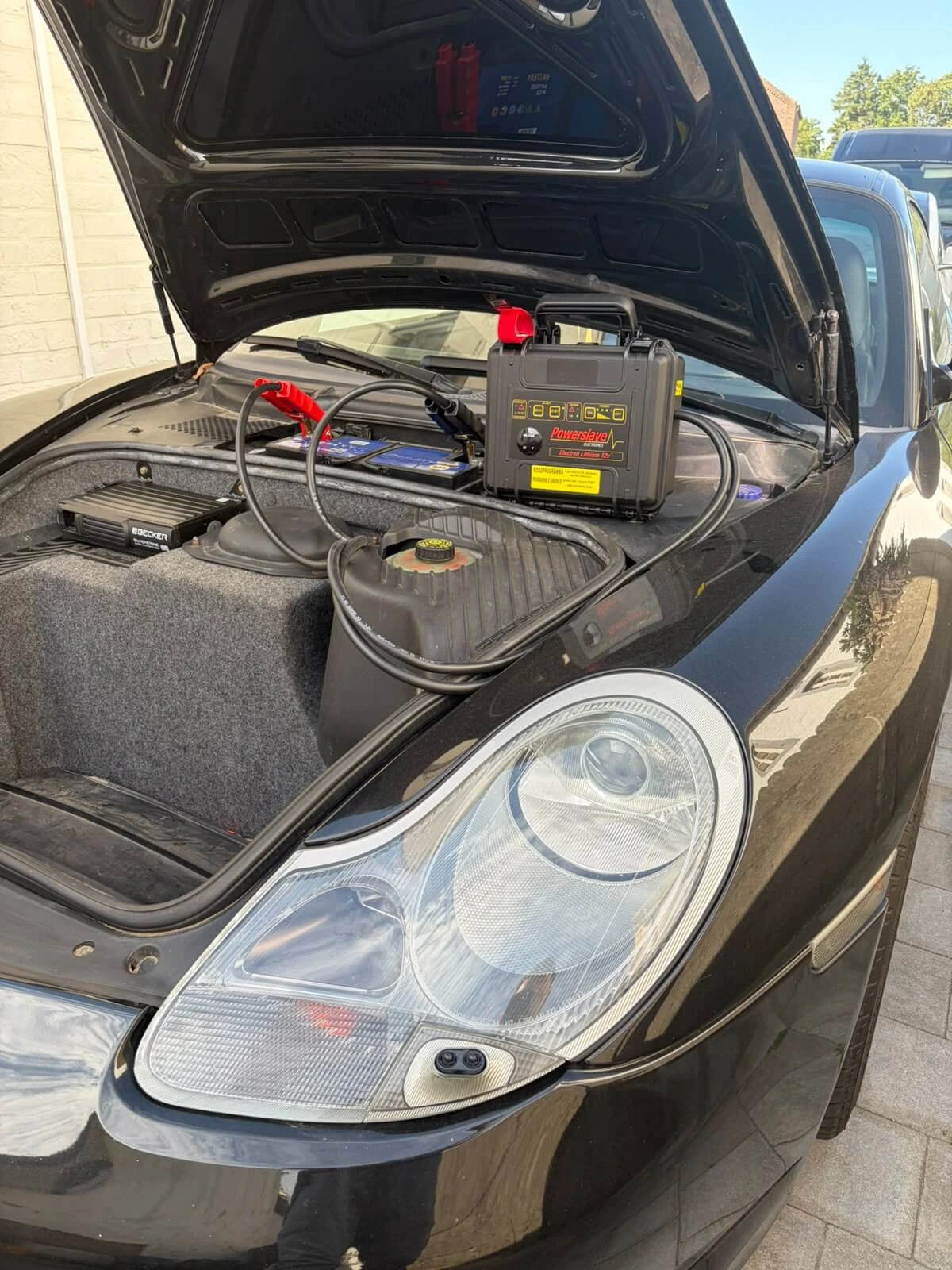 Powerslave Electron Lithium 12V-startbooster aangesloten op een auto met open kap